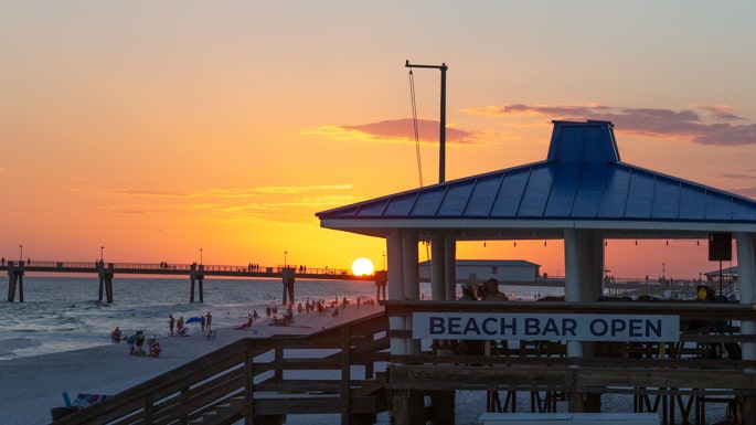 Enjoy a beverage at Tripp Tide Beach Bar, the gulf front beach bar. Beach Bar during sunset the gulf front The Island by Hotel RL.